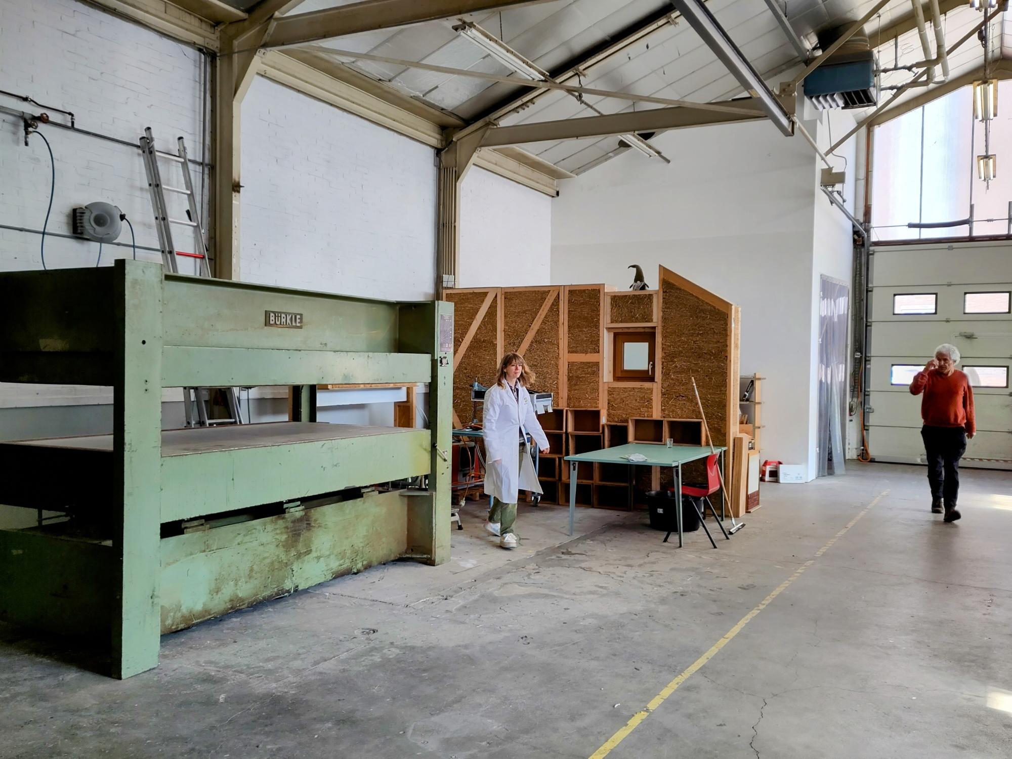 Pers in grote hal, met persoon in labjas